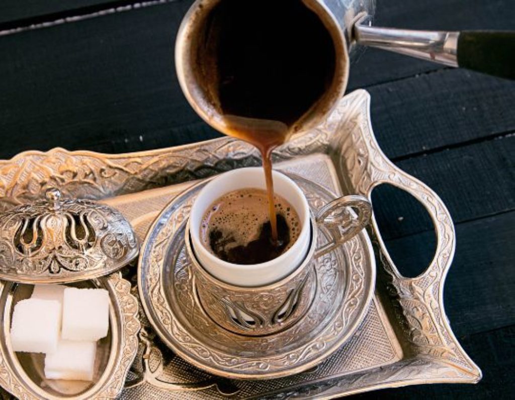 Turkish Coffee Pouring into Demitasse Cup with sugar