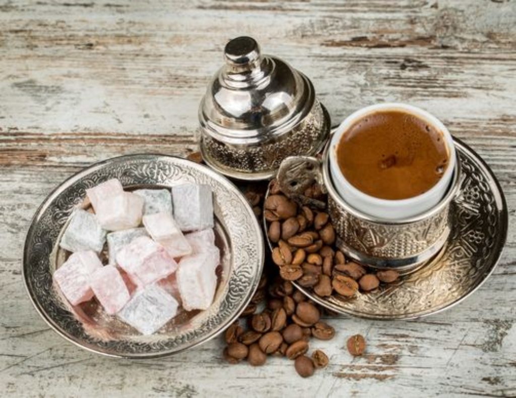 Cup of Turkish coffee served with coffee beans and Turkish delight treats