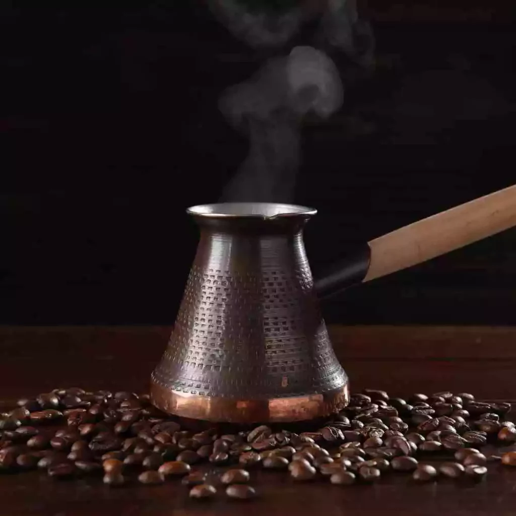 traditional turkish coffee pot with some roasted coffee beans